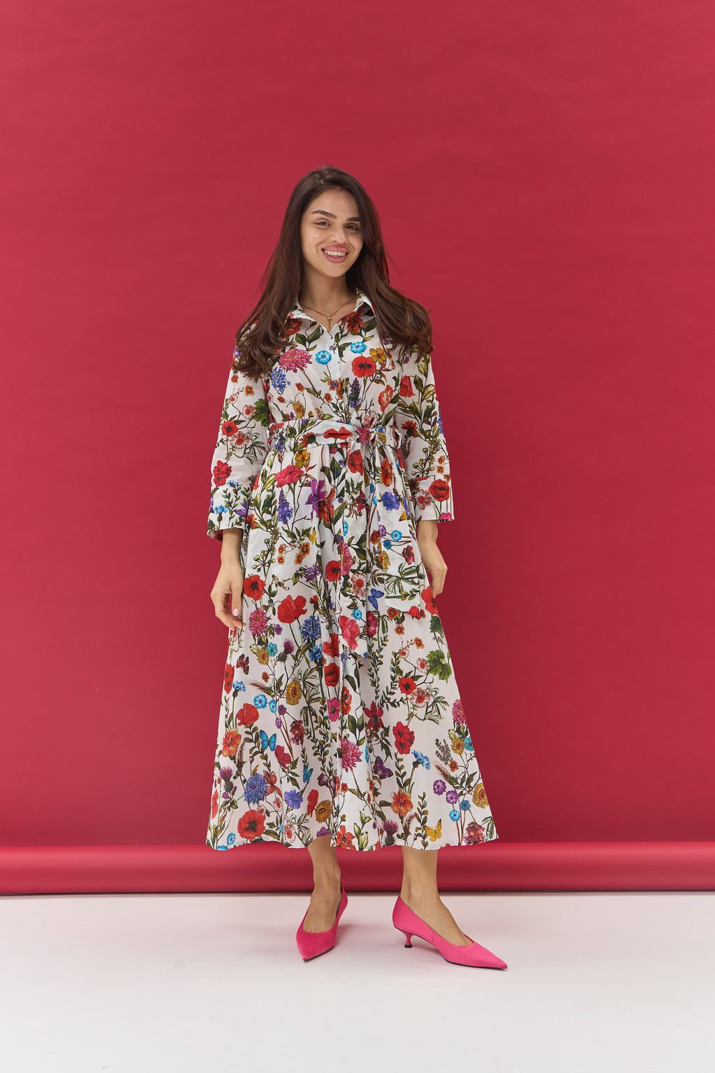 Woman wearing a floral dress against a red background